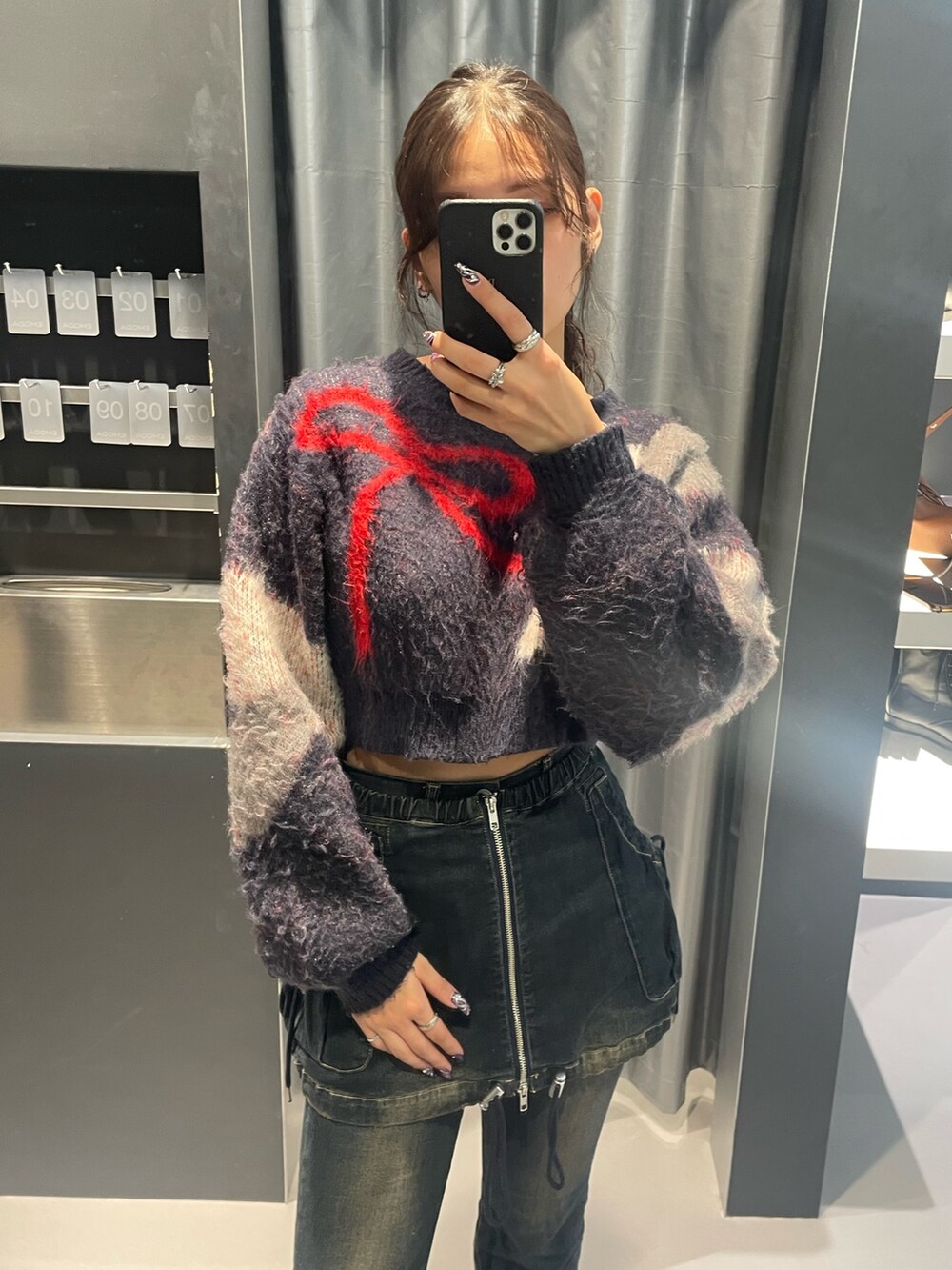 ブルー系のニット/セーター、ブルー系のデニムパンツ、ブラック系のブーツを着用したレディースの秋コーディネートの3枚目の写真