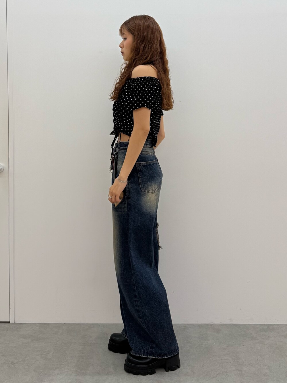 ブラック系のTシャツ/カットソー、ブルー系のデニムパンツ、ブラック系のブーツを着用したレディースの夏コーディネートの2枚目の写真