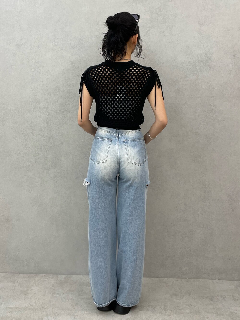 ブラック系のタンクトップ、ホワイト系のキャミソール、ブルー系のデニムパンツを着用したレディースの春コーディネートの3枚目の写真