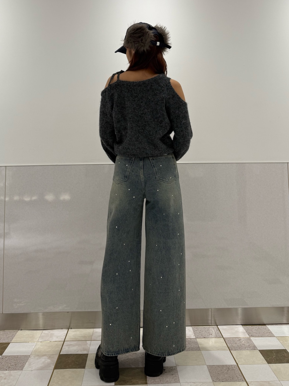 グレー系のニット/セーター、ブラック系のブーツ、ブルー系のデニムパンツを着用したレディースの冬コーディネートの3枚目の写真