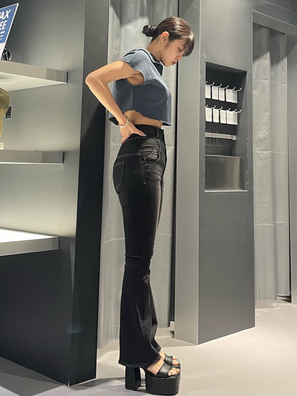 ブラック系のデニムパンツ、ブラック系のサンダル、ブルー系のTシャツ/カットソーを着用したレディースの夏コーディネートの2枚目の写真