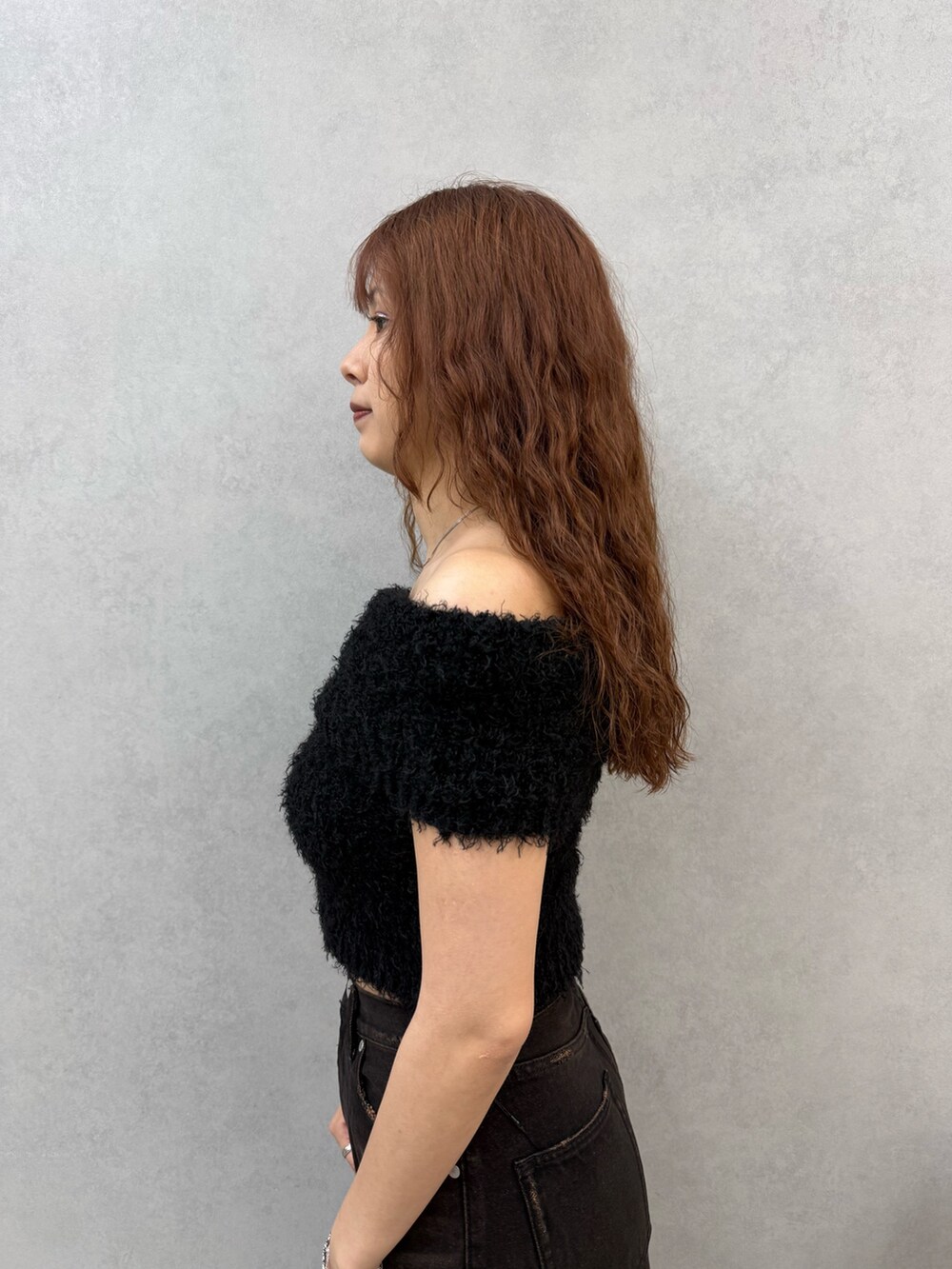 ブラック系のニット/セーター、ブラック系のデニムパンツ、ブラウン系のサンダルを着用したレディースの夏コーディネートの5枚目の写真