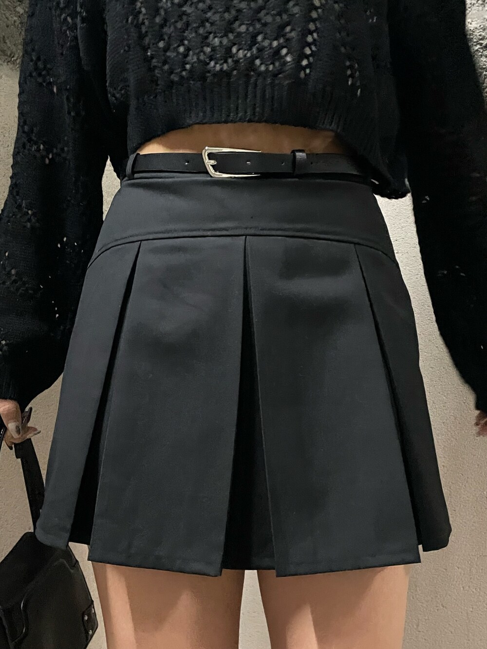 ブラック系のニット/セーター、ホワイト系のキャミソール、ブラック系のスカートを着用したレディースの春コーディネートの7枚目の写真