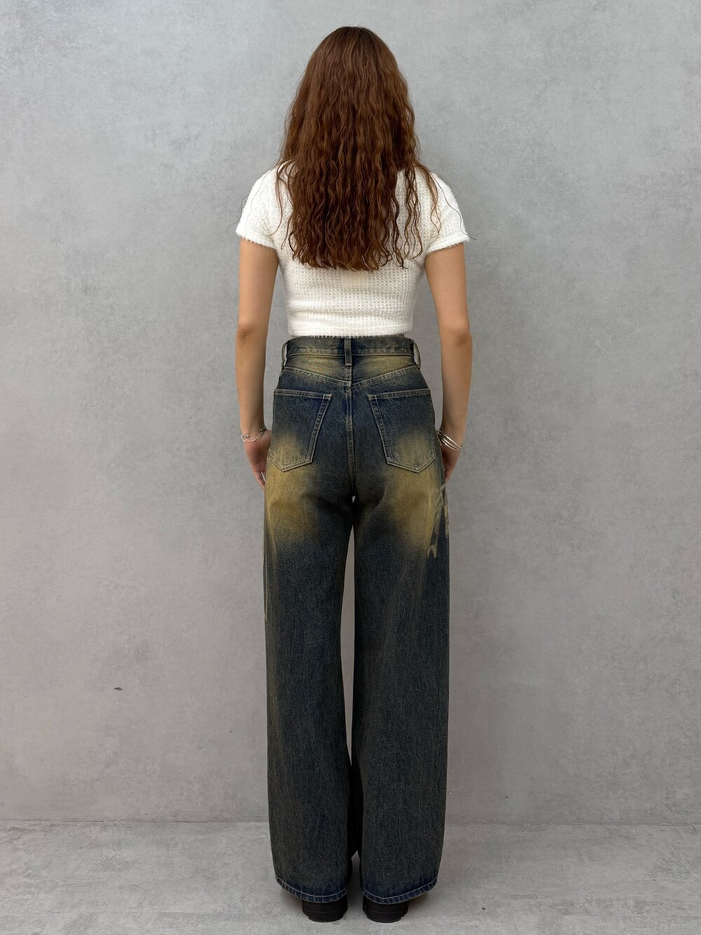 ホワイト系のTシャツ/カットソー、ブルー系のデニムパンツ、ブラック系のブーツを着用したレディースの夏コーディネートの3枚目の写真