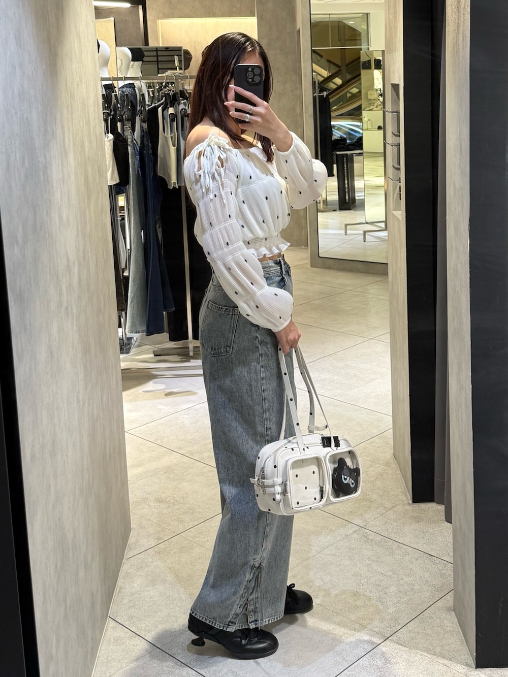 ホワイト系のTシャツ/カットソー、ブルー系のデニムパンツ、ホワイト系のショルダーバッグを着用したレディースの春コーディネートの2枚目の写真