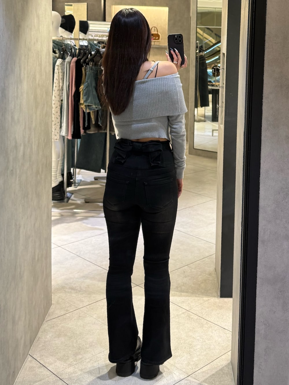 グレー系のニット/セーター、ブラック系のデニムパンツ、ブラック系のブーツを着用したレディースの春コーディネートの3枚目の写真