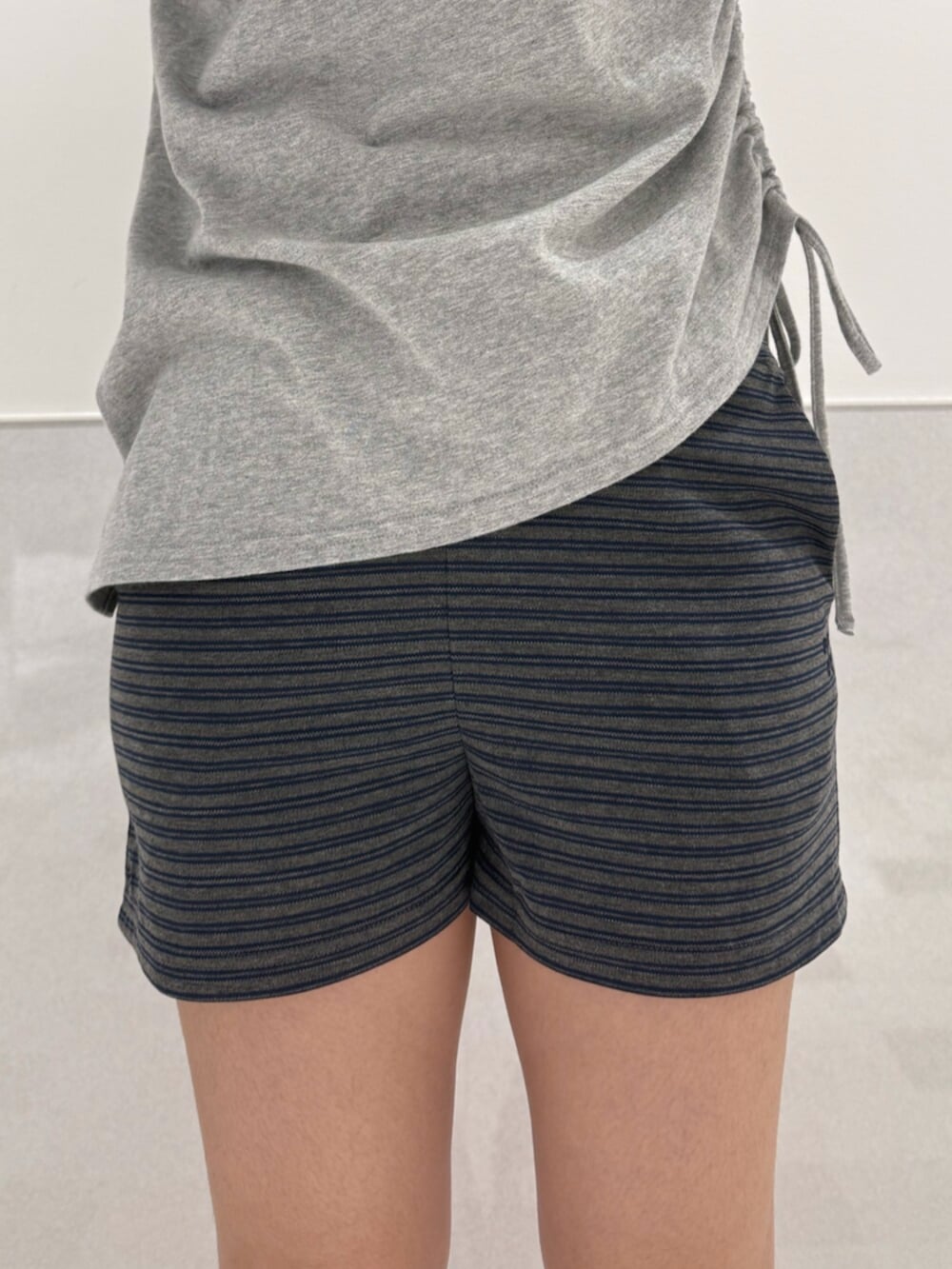 グレー系のTシャツ/カットソー、ブラック系のサンダル、ブラック系のハンドバッグを着用したレディースの夏コーディネートの5枚目の写真