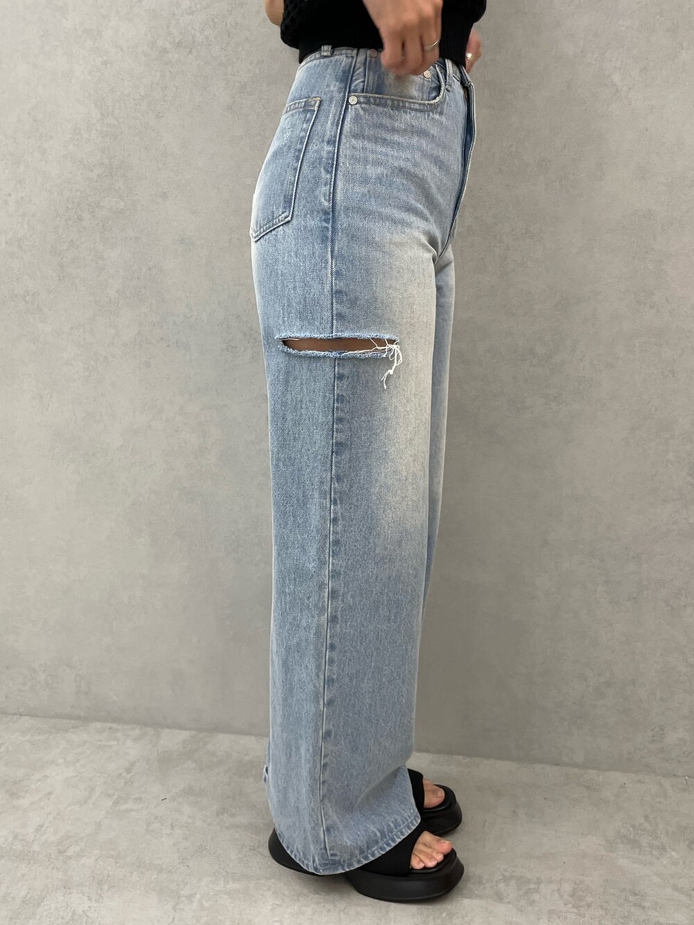 ブラック系のタンクトップ、ホワイト系のキャミソール、ブルー系のデニムパンツを着用したレディースの春コーディネートの8枚目の写真