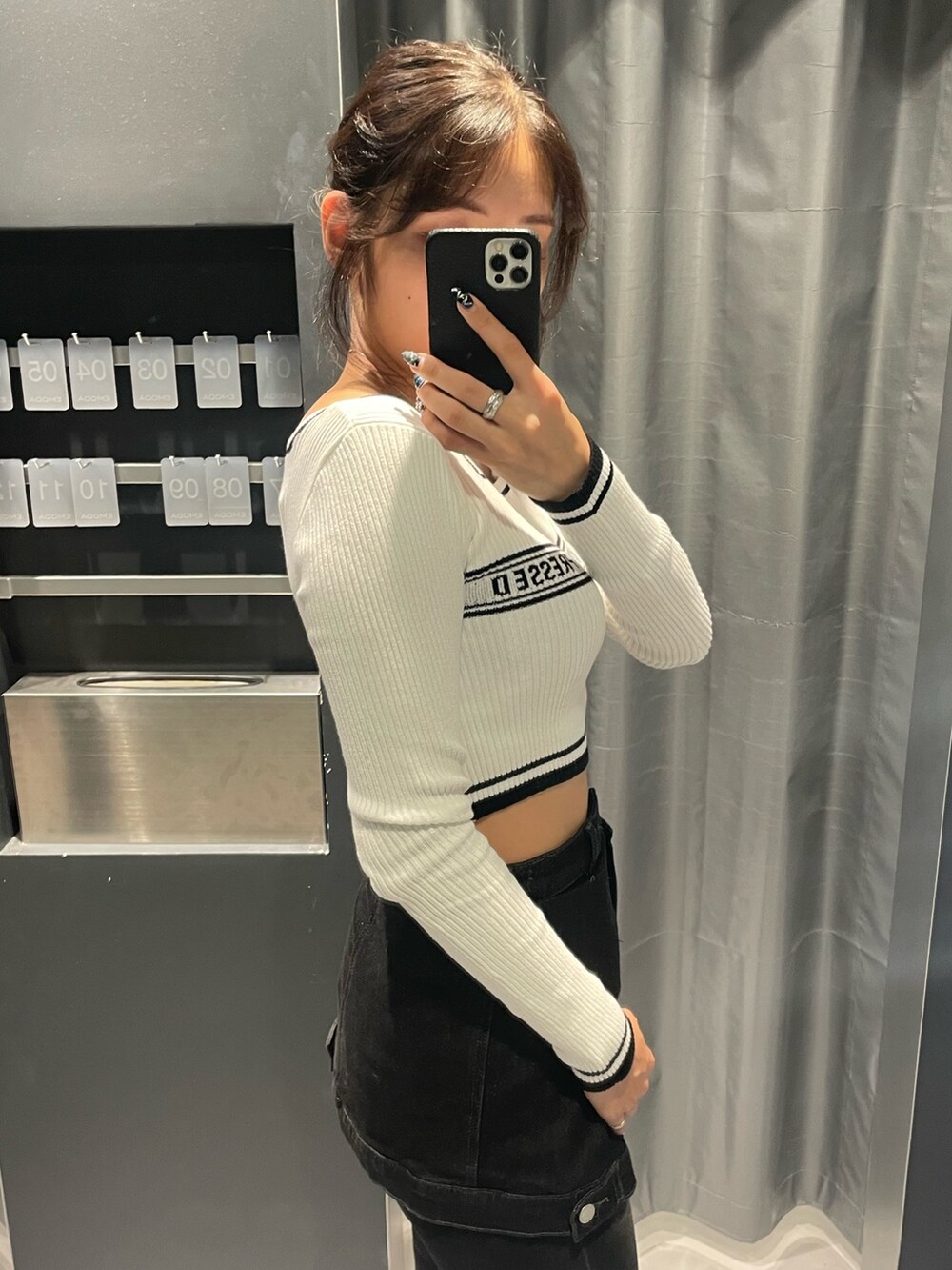 ホワイト系のニット/セーター、ブラック系のデニムパンツ、ブラック系のブーツを着用したレディースの秋コーディネートの5枚目の写真