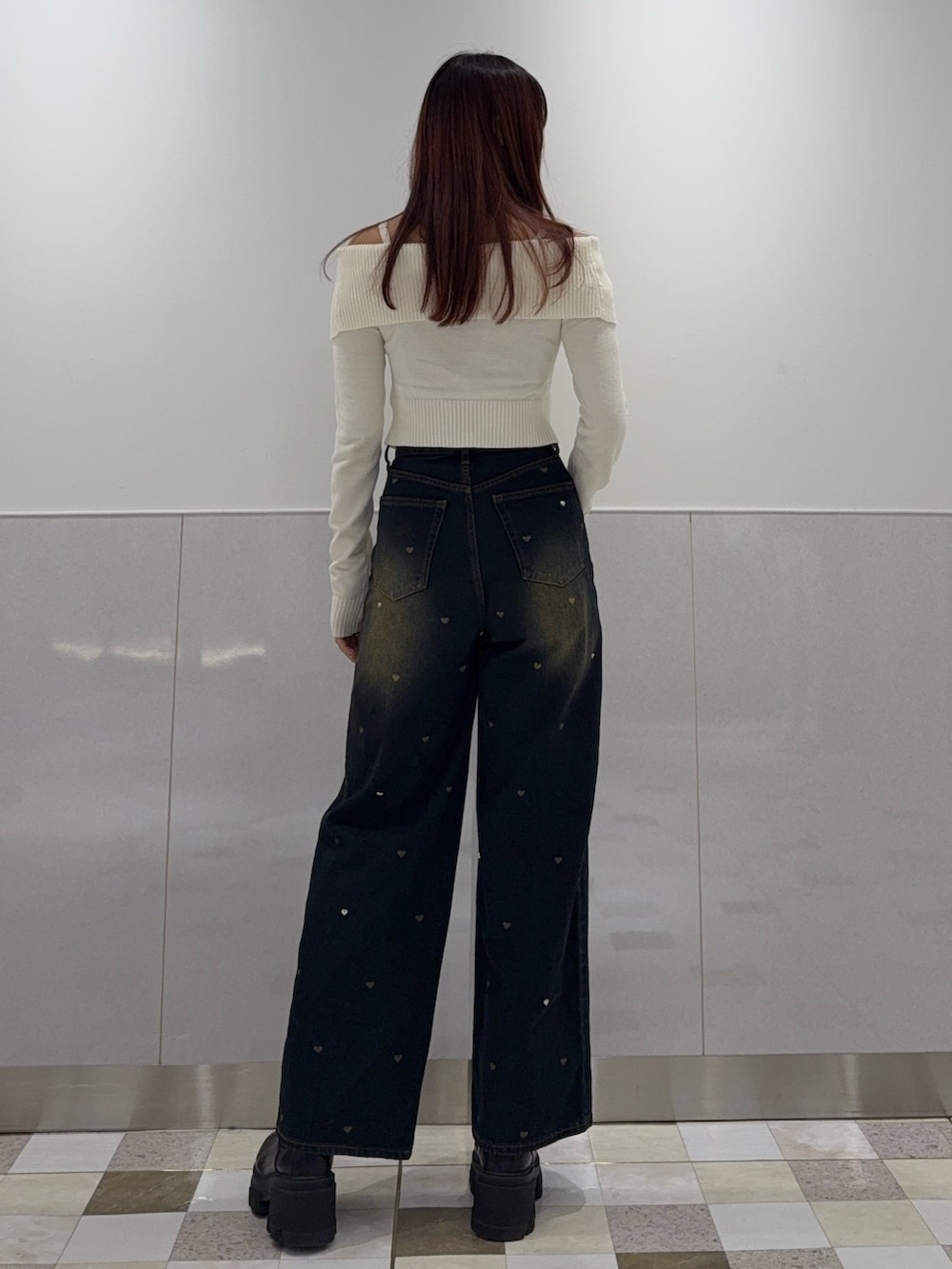 ホワイト系のニット/セーター、ブルー系のデニムパンツ、ブラック系のブーツを着用したレディースの秋コーディネートの3枚目の写真