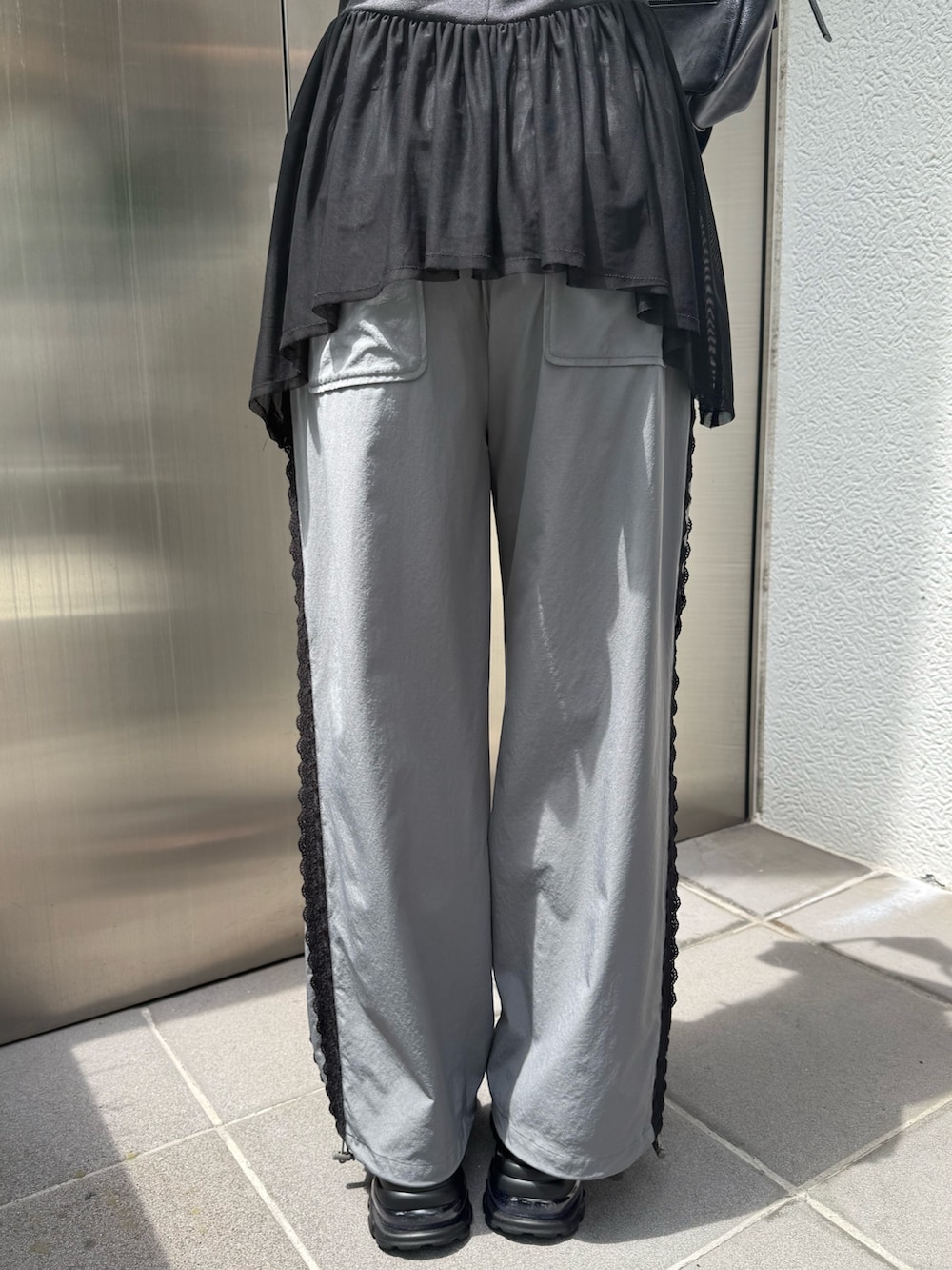 ブラック系のTシャツ/カットソー、ブラック系のハンドバッグ、グレー系のその他パンツを着用したレディースの夏コーディネートの9枚目の写真