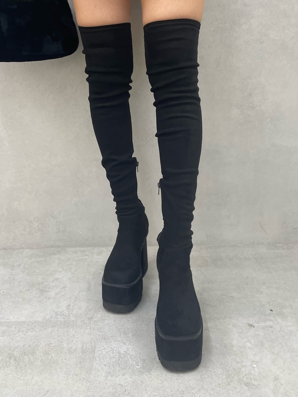 グレー系のワンピース、ブラック系のハンドバッグ、ブラック系のブーツを着用したレディースの冬コーディネートの7枚目の写真