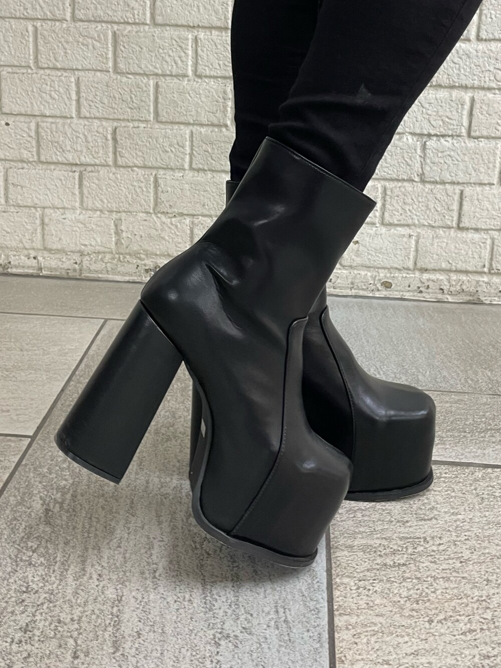 グレー系のニット/セーター、ブラック系のデニムパンツ、ブラック系のブーツを着用したレディースの冬コーディネートの9枚目の写真