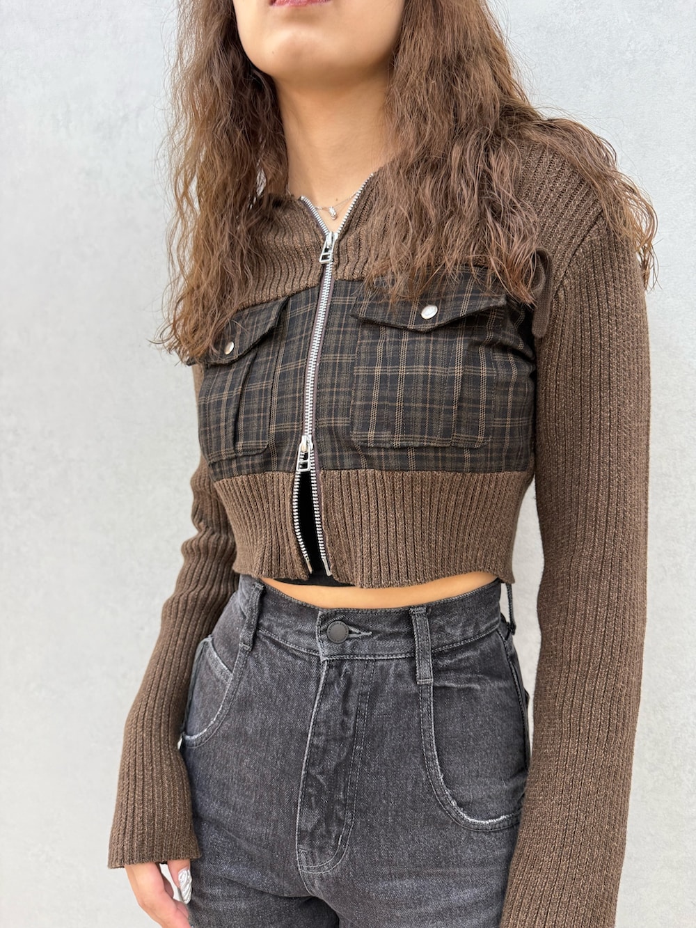 グリーン系のニット/セーター、ブラック系のデニムパンツ、ブラック系のブーツを着用したレディースの秋コーディネートの4枚目の写真