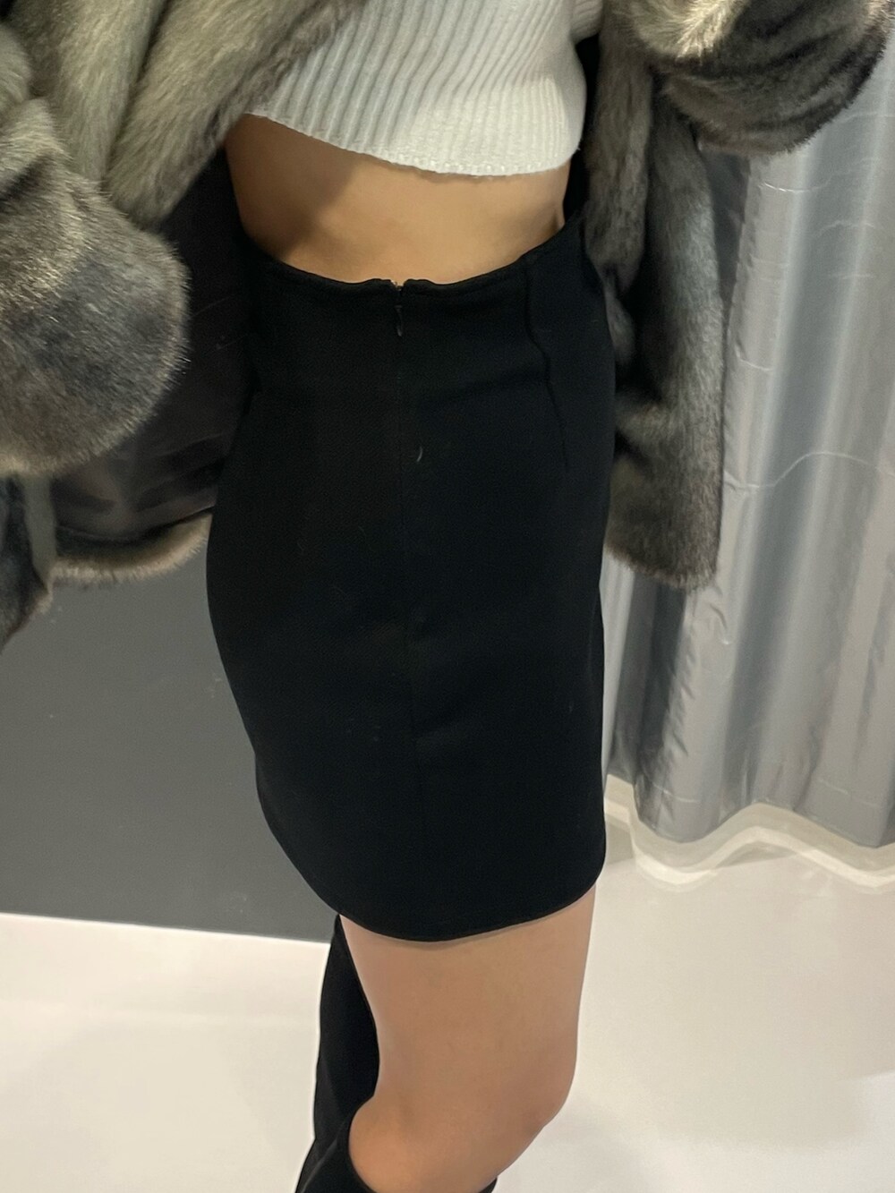 ホワイト系のニット/セーター、ブラック系のスカート、ブラック系のブルゾンを着用したレディースの冬コーディネートの7枚目の写真