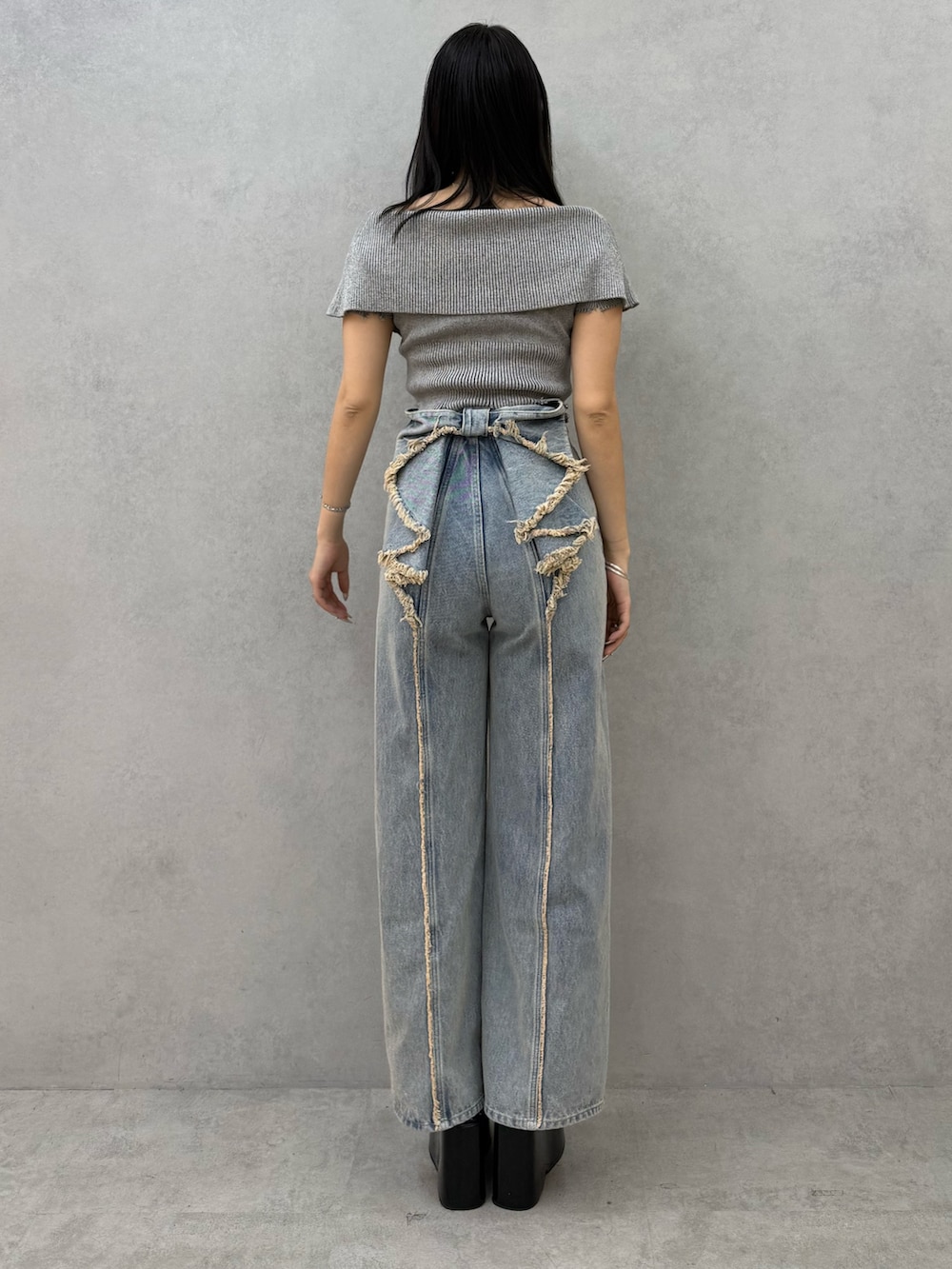 グレー系のニット/セーター、ブルー系のデニムパンツ、ブラック系のサンダルを着用したレディースの春コーディネートの3枚目の写真