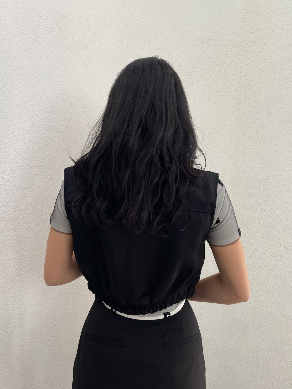 ホワイト系のTシャツ/カットソー、ブラック系のベスト、ブラック系のその他パンツを着用したレディースの春コーディネートの6枚目の写真