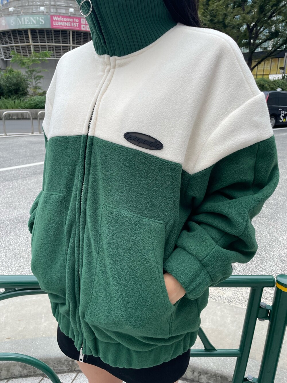 グリーン系のブルゾン、ブラック系のスカート、その他のブーツを着用したレディースの秋コーディネートの6枚目の写真