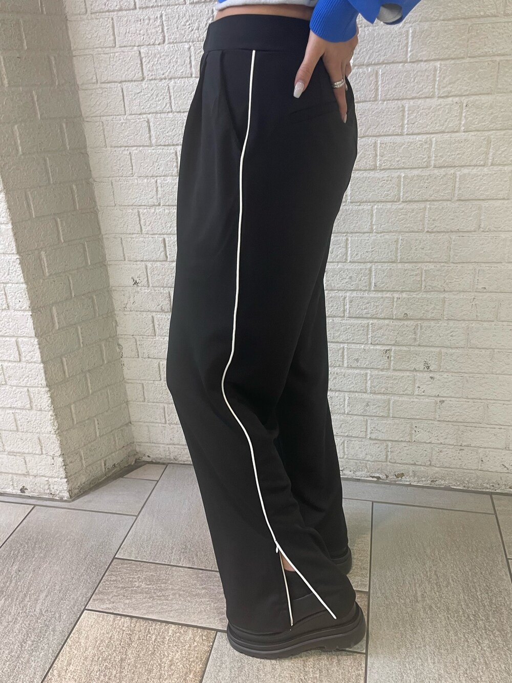 ブルー系のニット/セーター、ブラック系のスラックス、ブラック系のローファーを着用したレディースの冬コーディネートの8枚目の写真