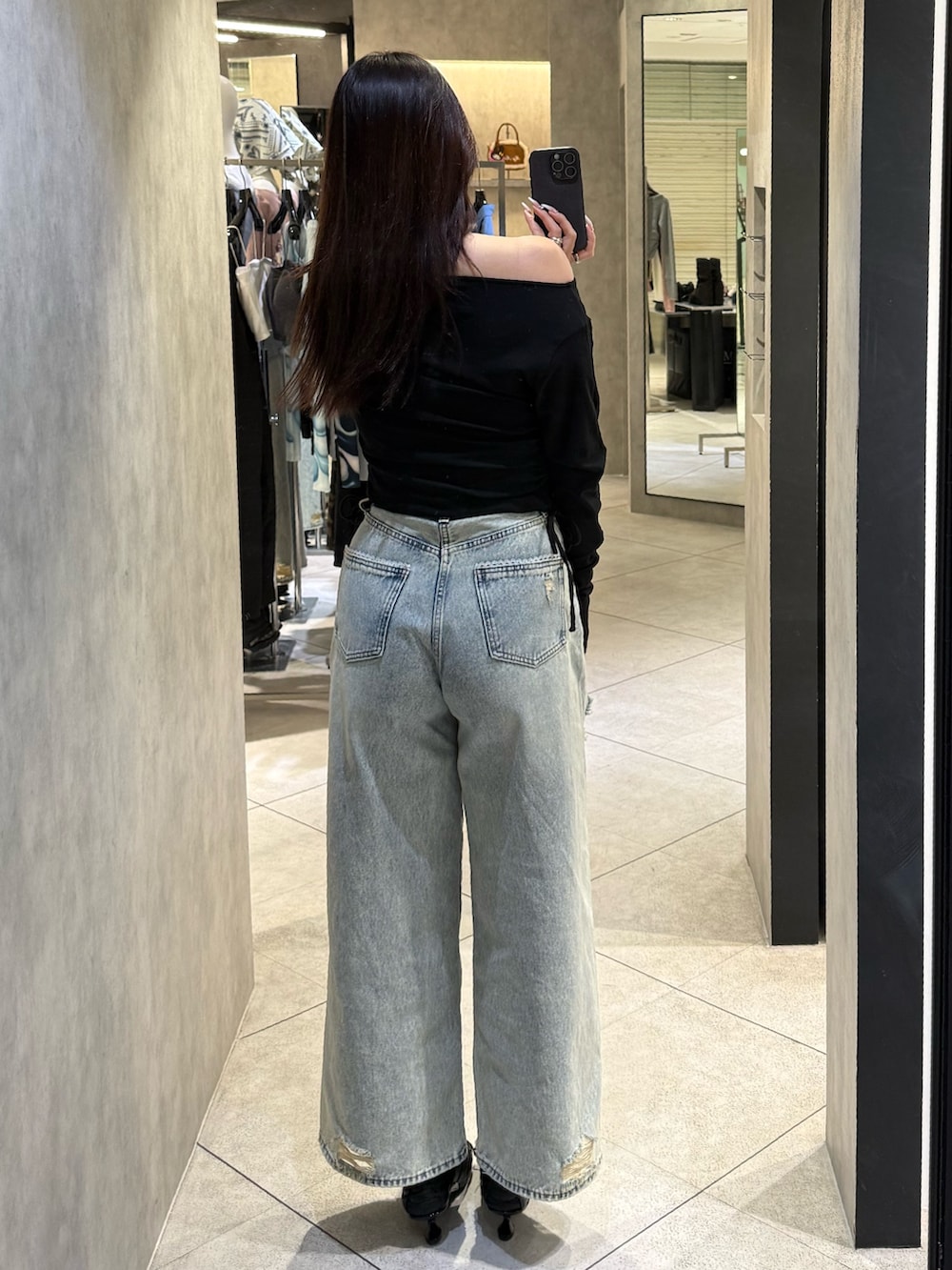 ブラック系のTシャツ/カットソー、ブルー系のデニムパンツ、ブラック系のスニーカーを着用したレディースの春コーディネートの3枚目の写真