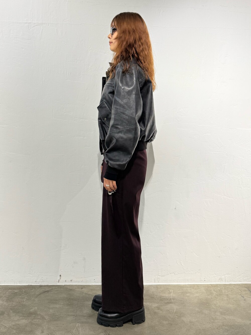 ブラック系のニット/セーター、ブラック系のブルゾン、ブラウン系のその他パンツを着用したレディースの秋コーディネートの2枚目の写真