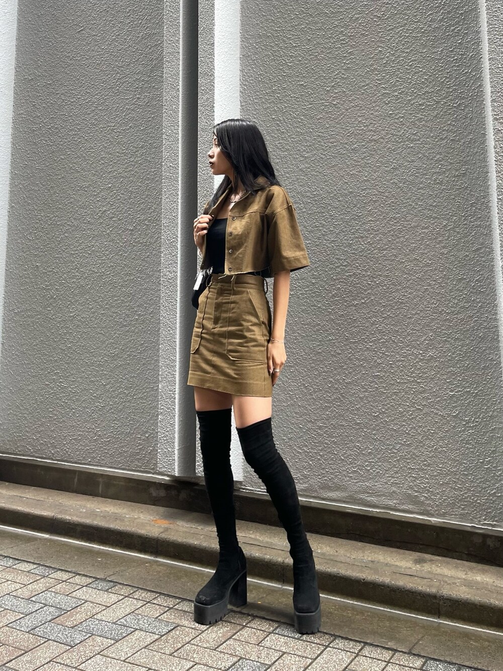 ブラウン系のシャツ/ブラウス、ブラック系のTシャツ/カットソー、ブラック系のハンドバッグを着用したレディースの秋コーディネートの2枚目の写真