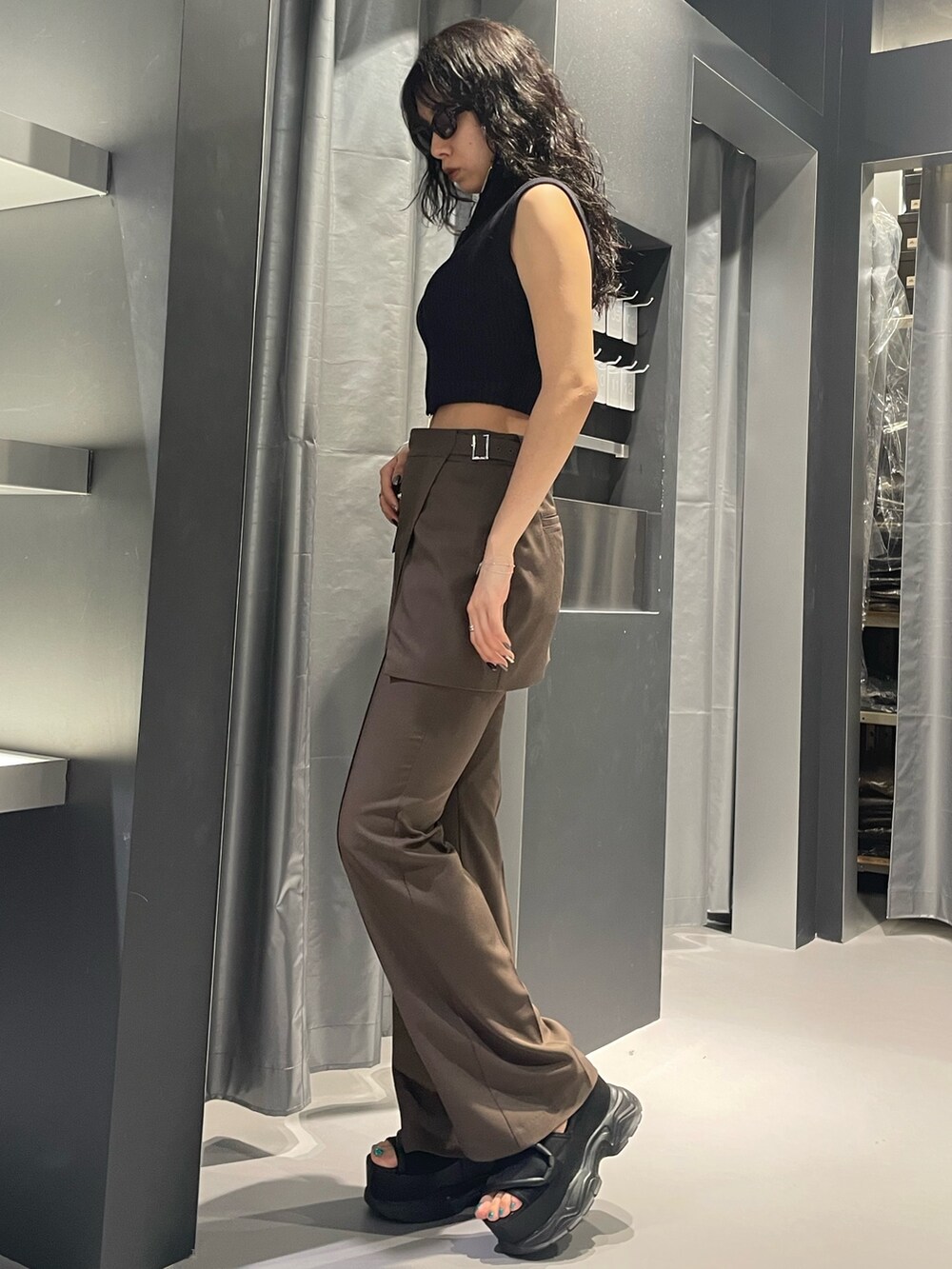 ブラック系のニット/セーター、ブラウン系のその他パンツ、ブラック系のサンダルを着用したレディースの夏コーディネートの2枚目の写真