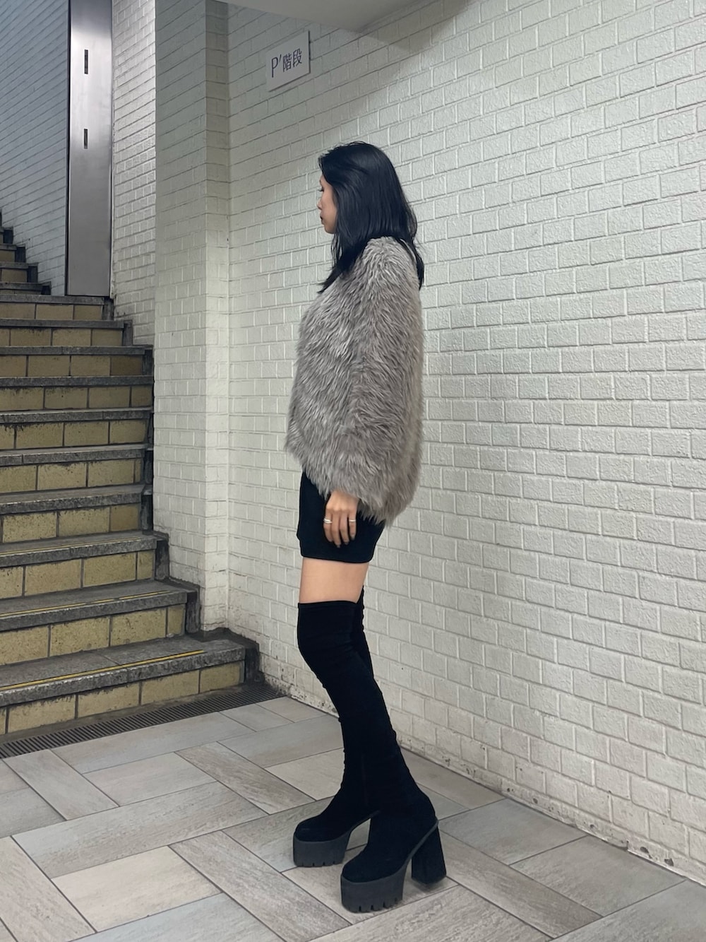 グレー系のカーディガン/ボレロ、ホワイト系のTシャツ/カットソー、ブラック系のスカートを着用したレディースの秋コーディネートの2枚目の写真