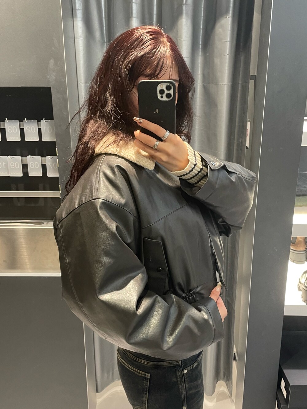 ホワイト系のニット/セーター、グレー系のブルゾン、ブルー系のデニムパンツを着用したレディースの秋コーディネートの5枚目の写真