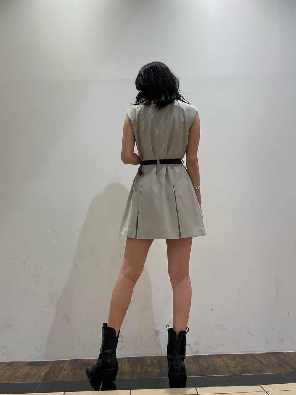 ブラック系のブーツ、ホワイト系のワンピース、ブラック系のベルトを着用したレディースの夏コーディネートの3枚目の写真