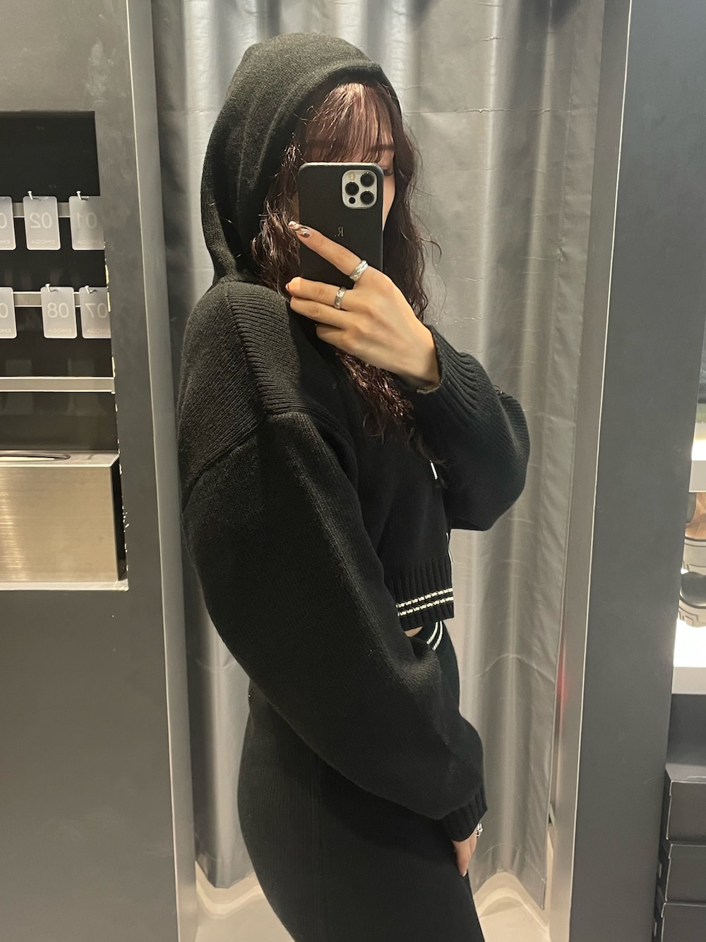 ブラック系のニット/セーター、ブラック系のスカート、シルバー系のブーツを着用したレディースの冬コーディネートの5枚目の写真