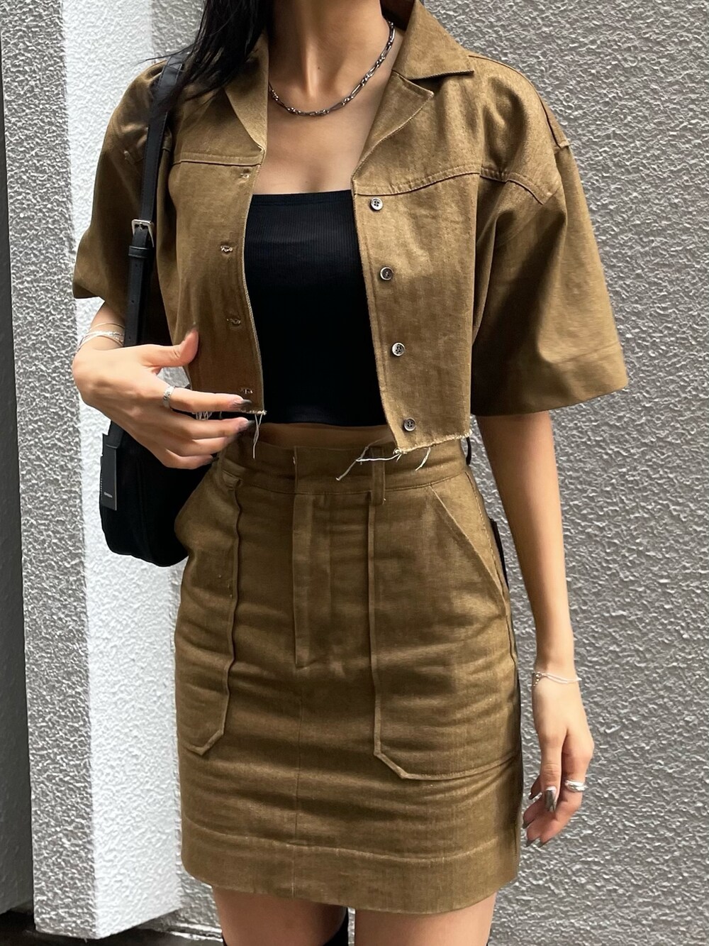 ブラウン系のシャツ/ブラウス、ブラック系のTシャツ/カットソー、ブラック系のハンドバッグを着用したレディースの秋コーディネートの4枚目の写真