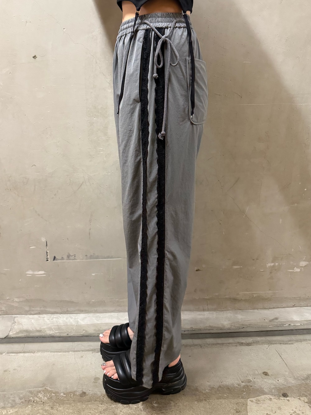 ブラック系のTシャツ/カットソー、グレー系のその他パンツ、ブラック系のハンドバッグを着用したレディースの夏コーディネートの6枚目の写真