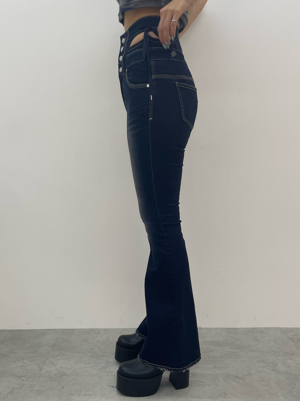 ブルー系のニット/セーター、ブルー系のデニムパンツ、ブラック系のブーツを着用したレディースの夏コーディネートの8枚目の写真