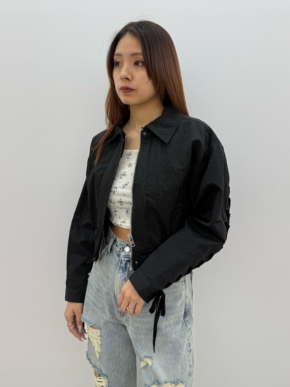 ブラック系のブルゾン、ホワイト系のTシャツ/カットソー、ブルー系のデニムパンツを着用したレディースの冬コーディネートの4枚目の写真