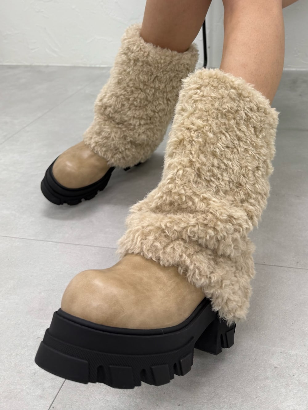 ブラック系のスカート、ホワイト系のブーツ、ブラック系のニット/セーターを着用したレディースの冬コーディネートの5枚目の写真