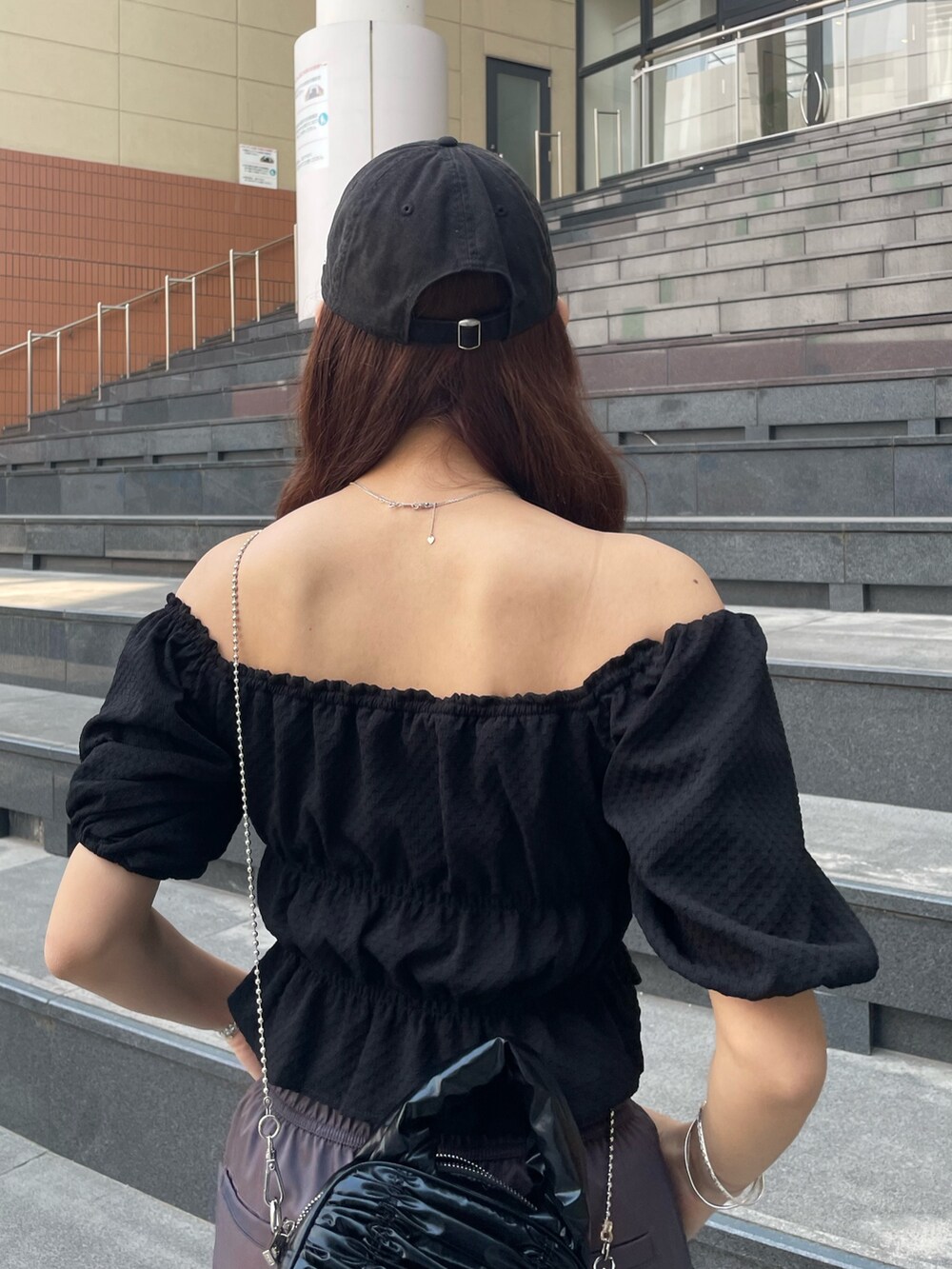 ブラック系のハンドバッグ、ブラック系のTシャツ/カットソー、ブラウン系のその他パンツを着用したレディースの春コーディネートの6枚目の写真