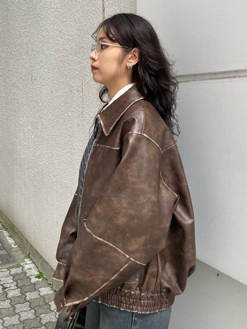 ホワイト系のシャツ/ブラウス、ブラウン系のブルゾン、ブルー系のデニムパンツを着用したレディースの秋コーディネートの5枚目の写真