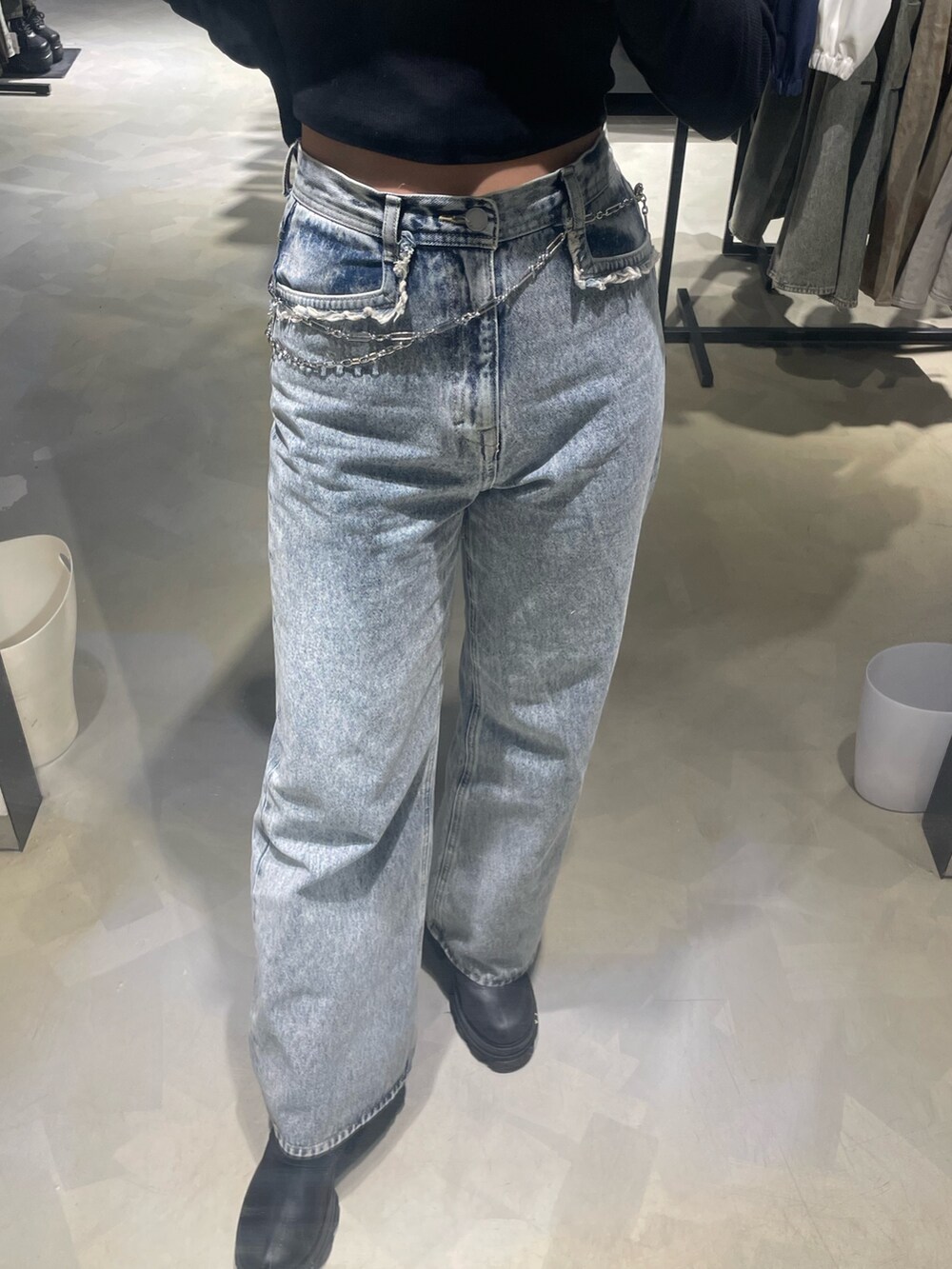 ブラック系のTシャツ/カットソー、ブルー系のデニムパンツ、ブラック系のブーツを着用したレディースの春コーディネートの6枚目の写真