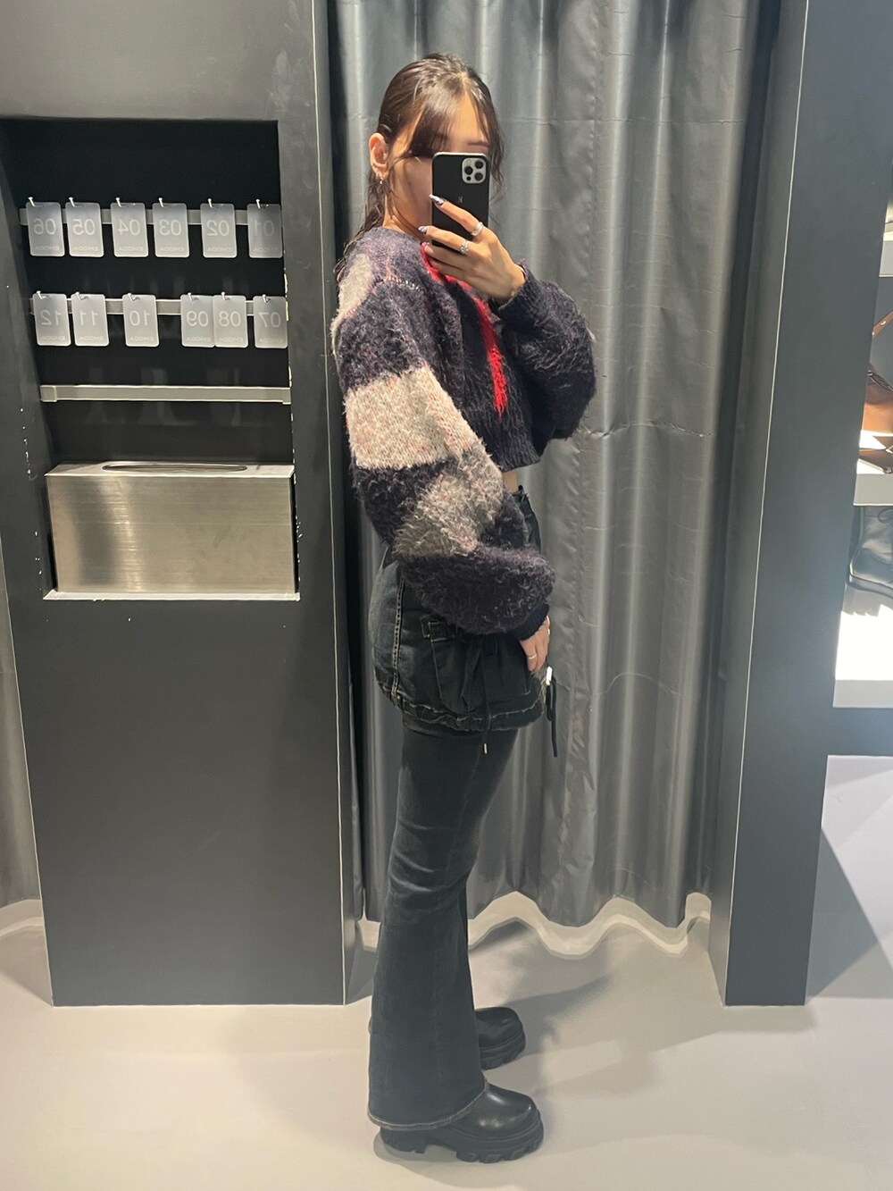 ブルー系のニット/セーター、ブルー系のデニムパンツ、ブラック系のブーツを着用したレディースの秋コーディネートの2枚目の写真