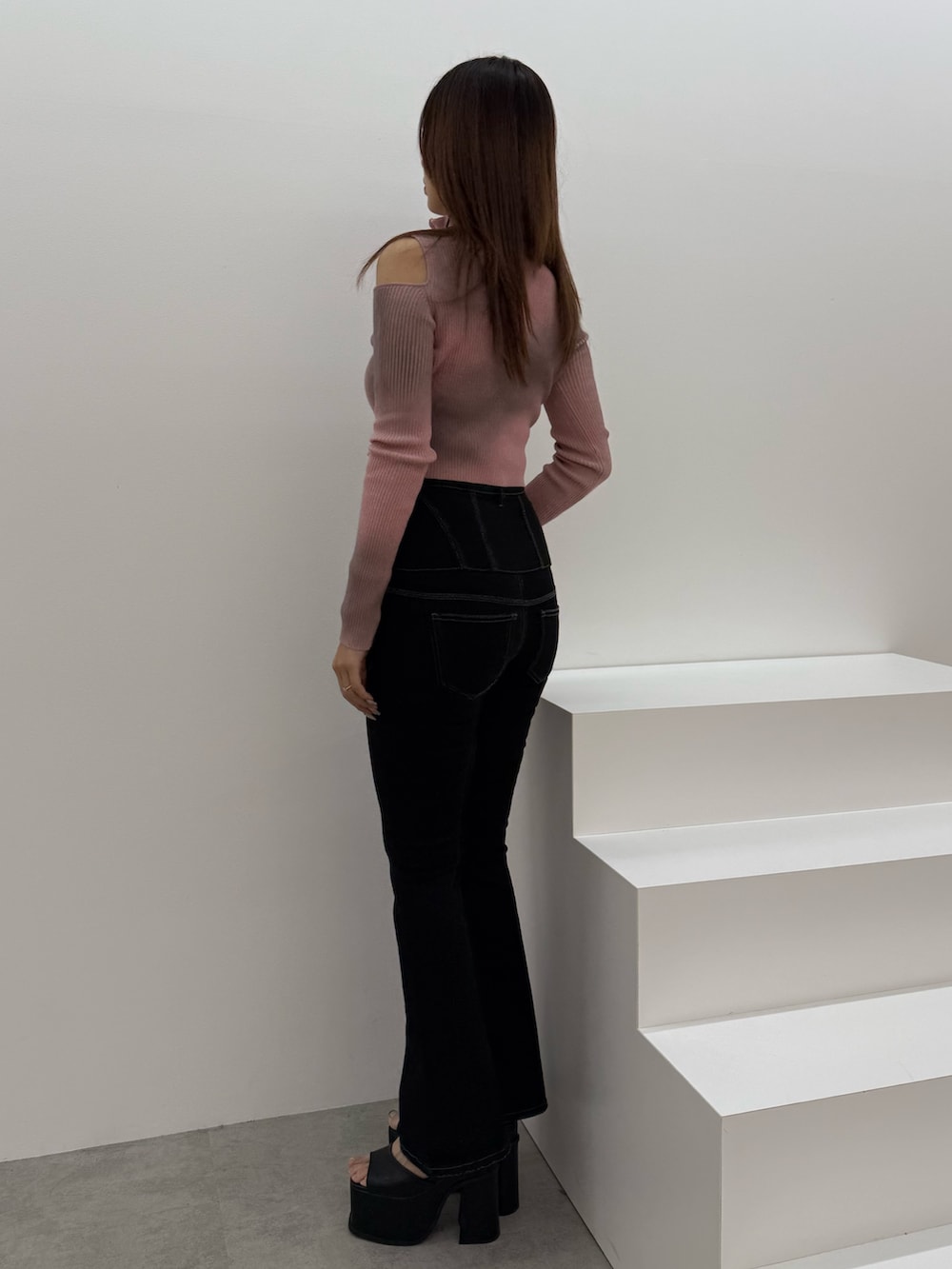 ピンク系のニット/セーター、ブラック系のデニムパンツ、ブラック系のサンダルを着用したレディースの冬コーディネートの2枚目の写真