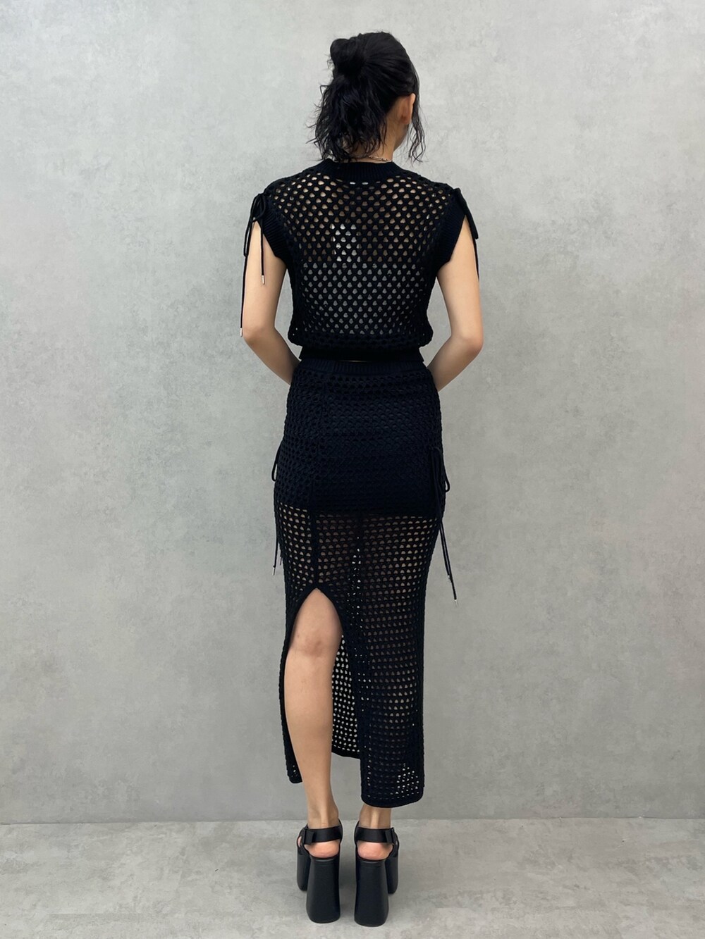 ホワイト系のキャミソール、ブラック系のタンクトップ、ブラック系のスカートを着用したレディースの春コーディネートの3枚目の写真