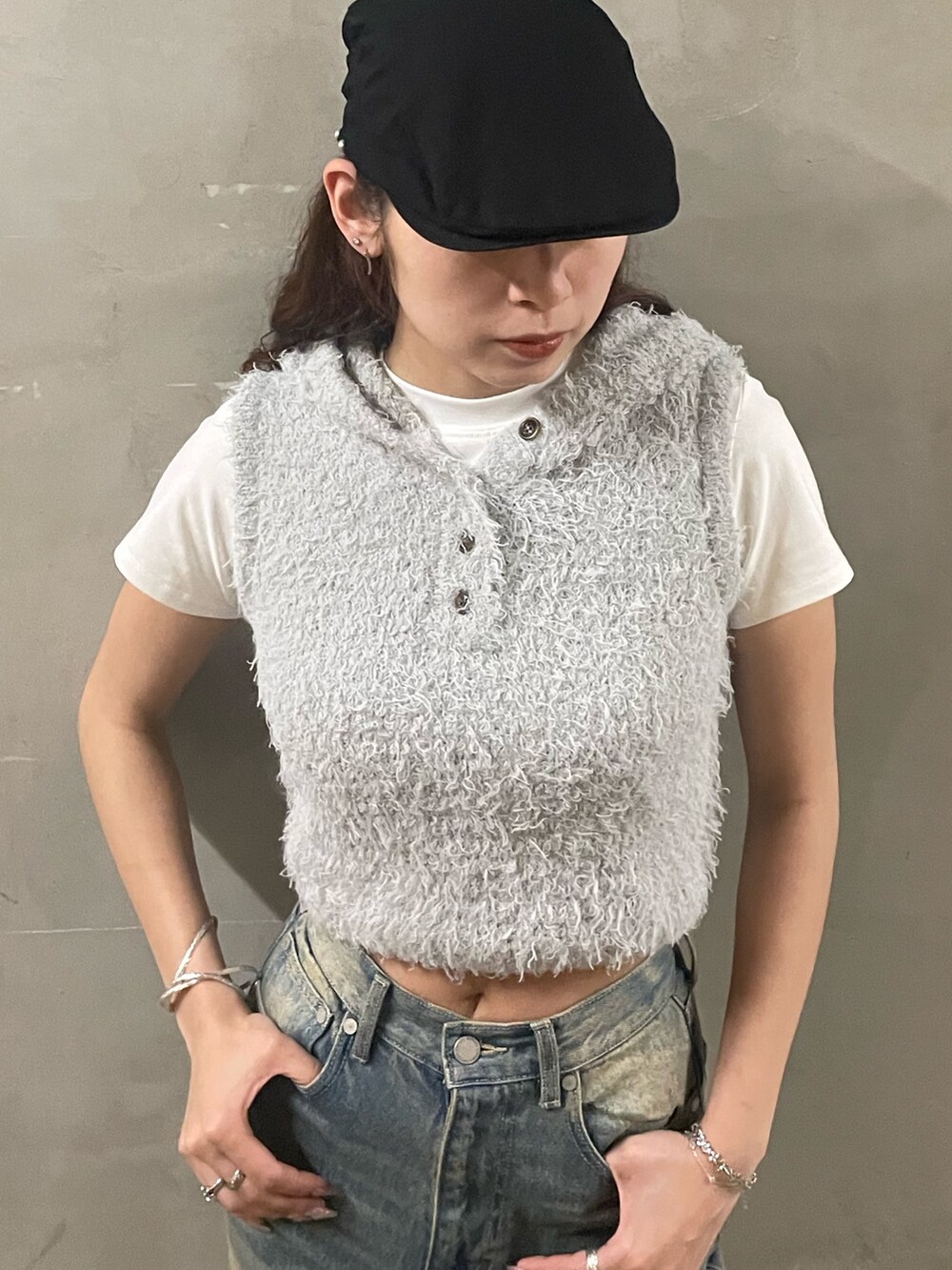 ホワイト系のTシャツ/カットソー、グレー系のニット/セーター、グレー系のスカートを着用したレディースの春コーディネートの4枚目の写真