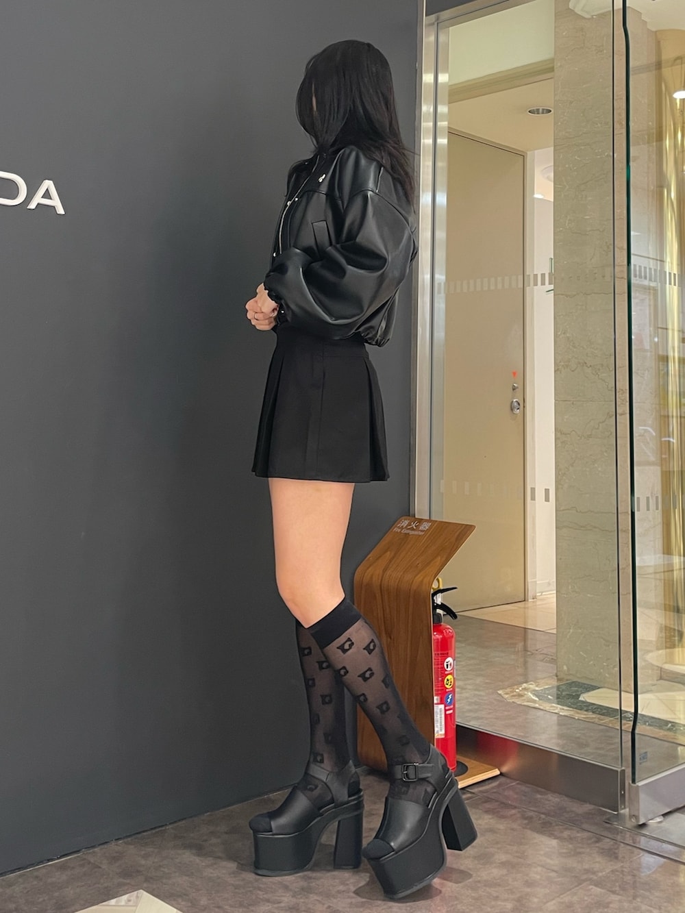 ホワイト系のタンクトップ、ブラック系のブルゾン、ブラック系のスカートを着用したレディースの春コーディネートの2枚目の写真