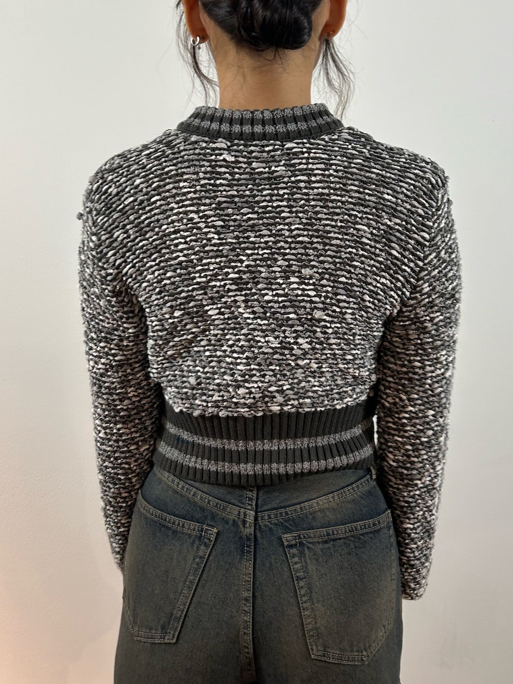 グレー系のカーディガン/ボレロ、ブルー系のデニムパンツ、ブラック系のショルダーバッグを着用したレディースの秋コーディネートの6枚目の写真