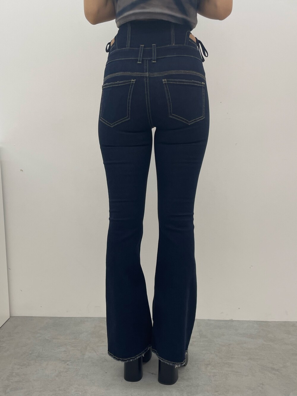 ブルー系のデニムパンツ、ブラック系のブーツ、シルバー系のネックレスを着用したレディースの夏コーディネートの7枚目の写真
