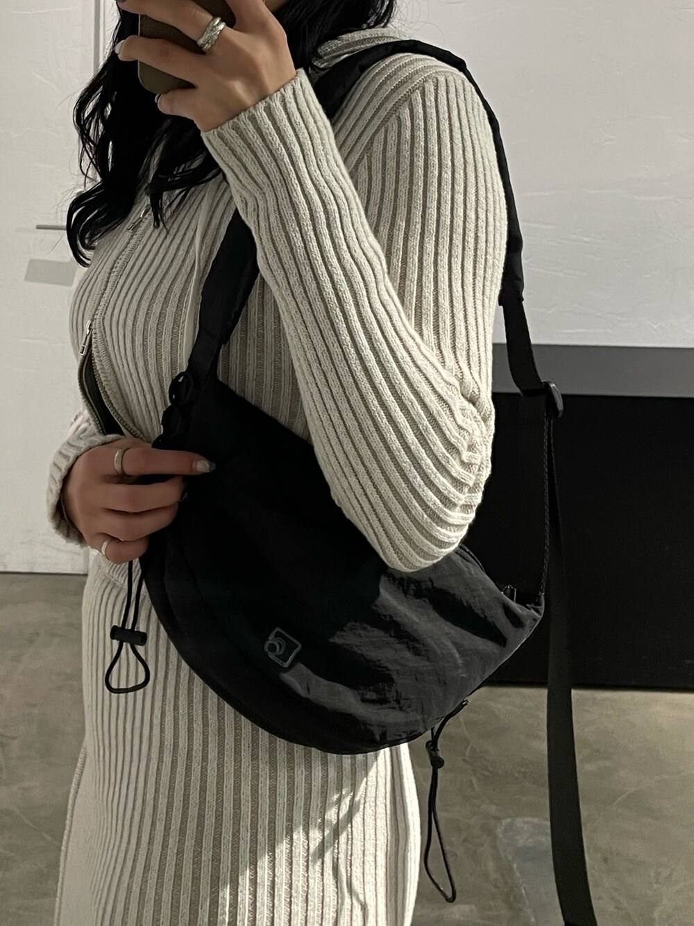 ホワイト系のワンピース、ブラック系のキャミソール、ブラック系のブーツを着用したレディースの春コーディネートの8枚目の写真