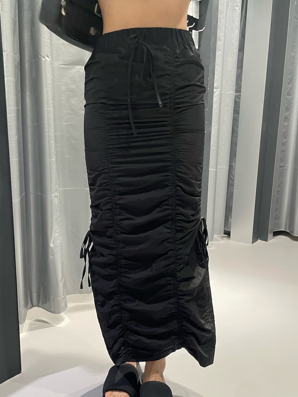 ブラック系のTシャツ/カットソー、ブラック系のスカート、ブラック系のサンダルを着用したレディースの夏コーディネートの7枚目の写真