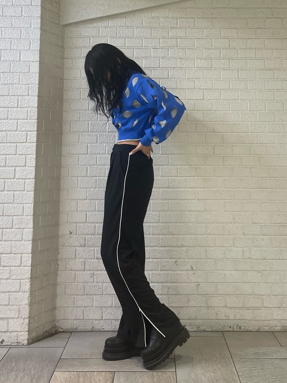 ブルー系のニット/セーター、ブラック系のスラックス、ブラック系のローファーを着用したレディースの冬コーディネートの2枚目の写真