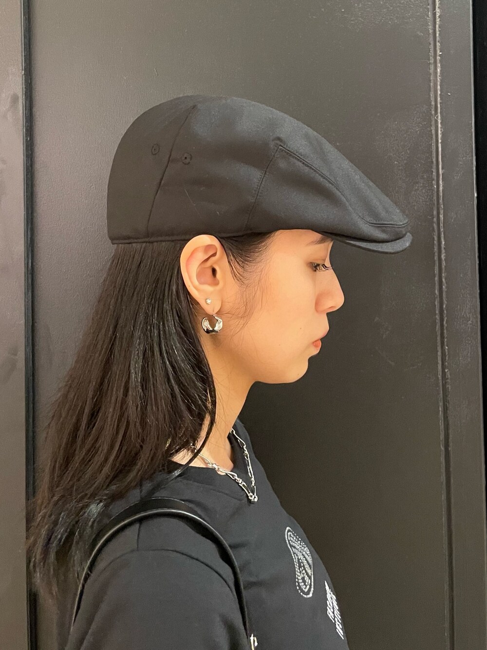 ブラック系のTシャツ/カットソー、ブラック系のショルダーバッグ、ブルー系のデニムパンツを着用したレディースの夏コーディネートの6枚目の写真